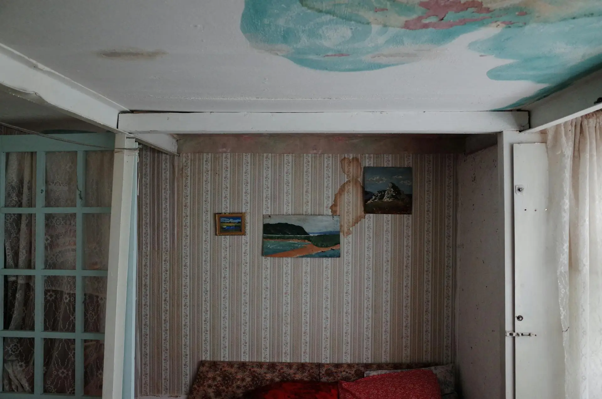 Room with water-damaged walls and ceiling